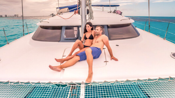 Pareja relajada en un catamarán de Cancun Sailing