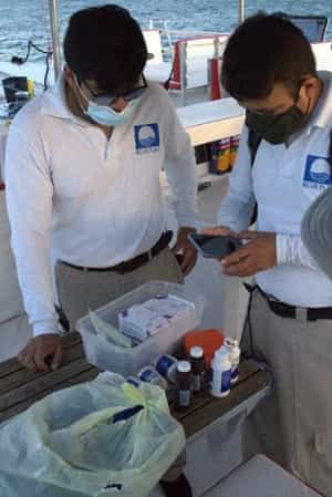 Evaluadores de Blue Flag México revisando el botiquín de una embarcación de Cancun Sailing.