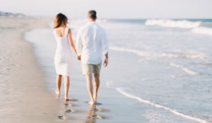 pareja caminando a la orilla de una playa en Cancún